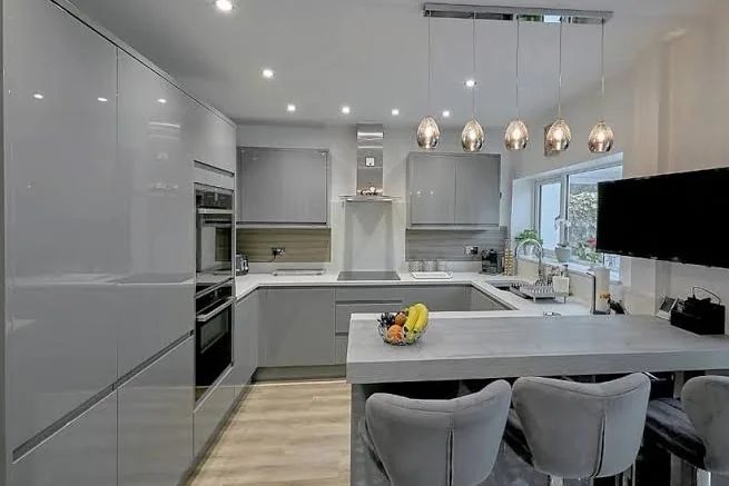 Grey gloss handleless kitchen with breakfast bar and pendant lighting