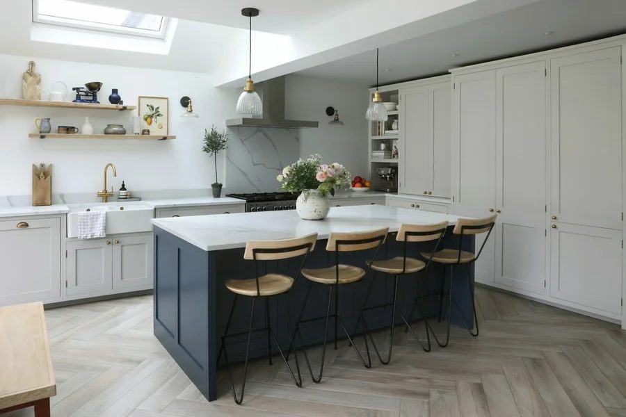 Pale grey shaker kitchen with navy island and marble worktop